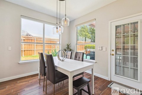 A dining room with a table and chairs.