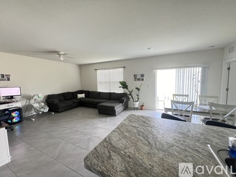 A living room with a grey sofa and a grey rug.