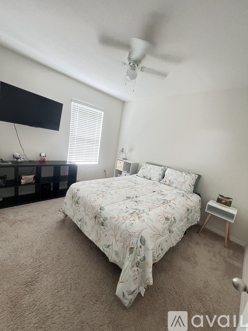 A bedroom with a large bed and a ceiling fan.