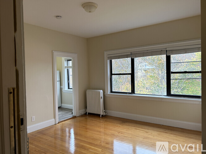 A room with a window and a radiator on the floor.