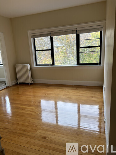 A room with wooden floors and a large window.