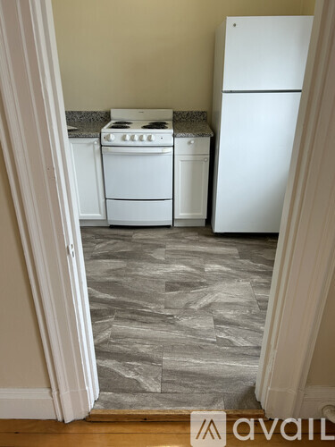 A kitchen with a white fridge and white stove top and dishwasher.