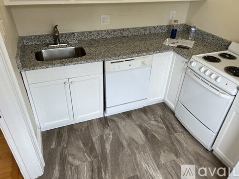 A kitchen with white appliances and cabinets.