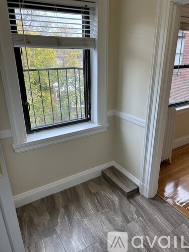 A room with a window and a balcony.