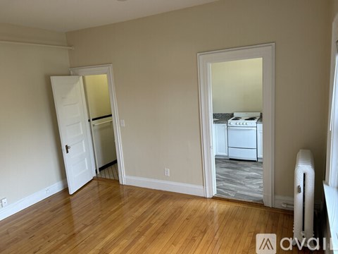 A room with a white door and a white fridge.