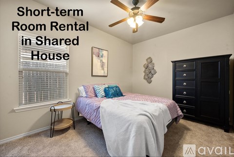 A bedroom with a bed, a ceiling fan, and a cabinet is available for short-term room rental in a shared house.