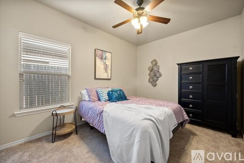 A bedroom with a bed, dresser, and window.
