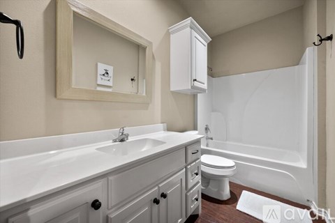 A white bathroom with a sink, toilet, and bathtub.
