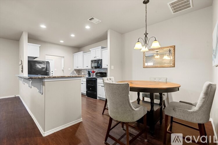 A kitchen with a bar area and a dining table with chairs.