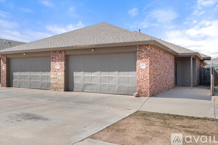 A house with a brick facade and three garage doors.
