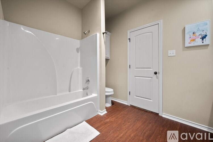 A bathroom with a white tub and toilet.