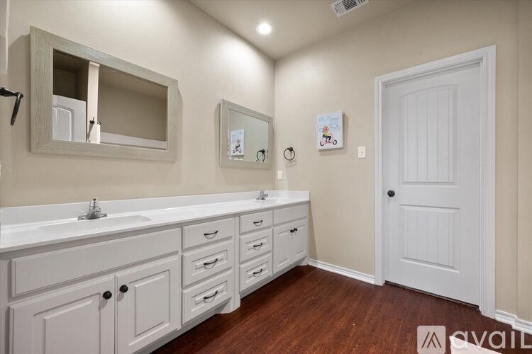 A bathroom with two sinks and a large mirror.