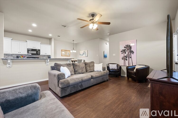 A living room with a grey couch and a wooden floor.