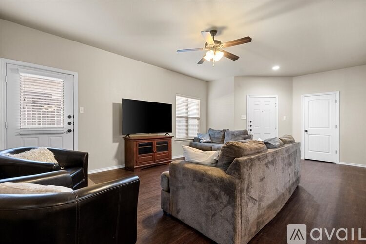 A living room with a brown couch and a flat screen TV.