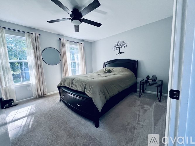 A bedroom with a large bed and a ceiling fan.