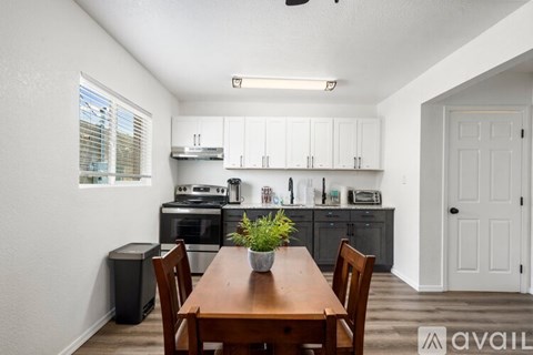 A kitchen with a table and chairs in front of it.