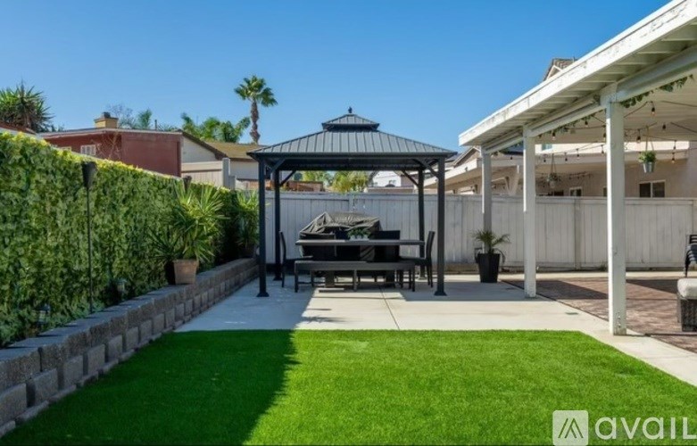 A backyard with a gazebo and a lawn.