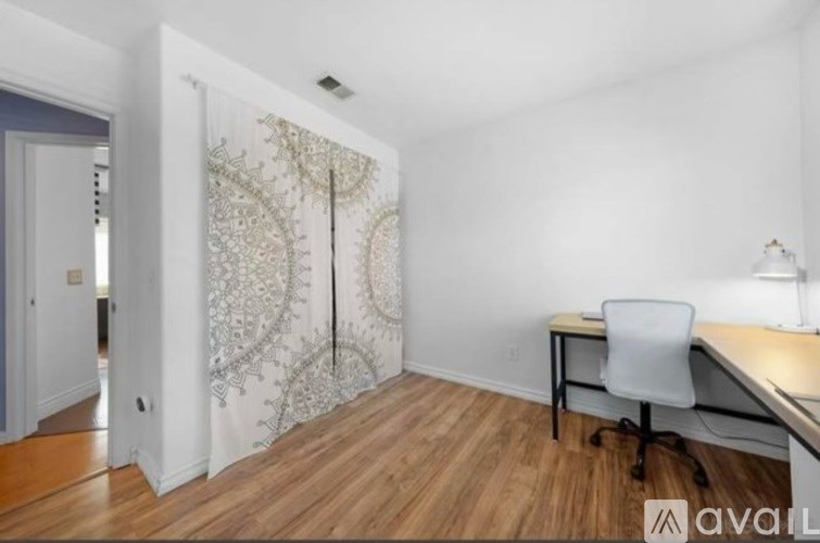 A room with a desk and a chair in it.