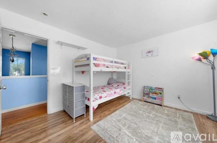 A room with two bunk beds and a desk.