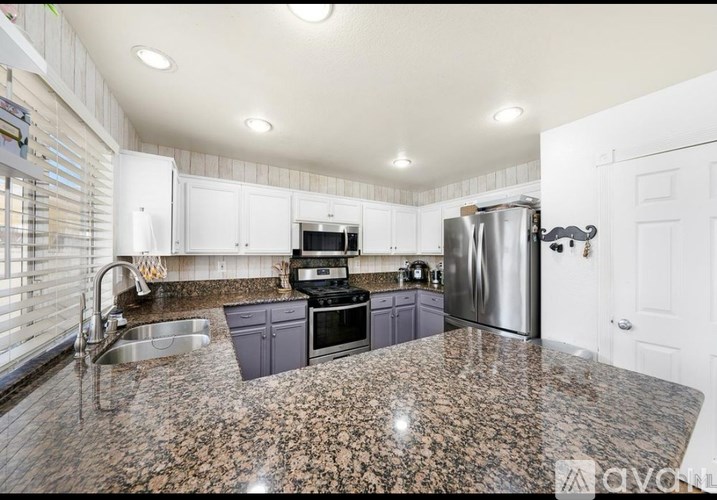 A kitchen with granite countertops and stainless steel appliances.