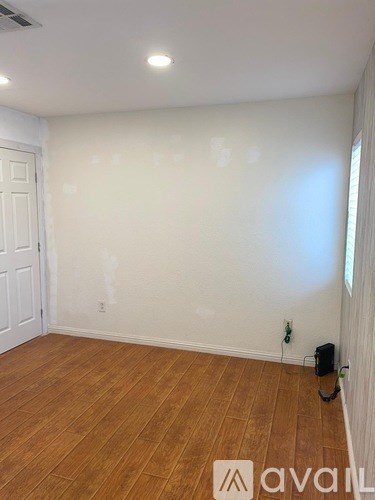 A room with wooden flooring and a white door.