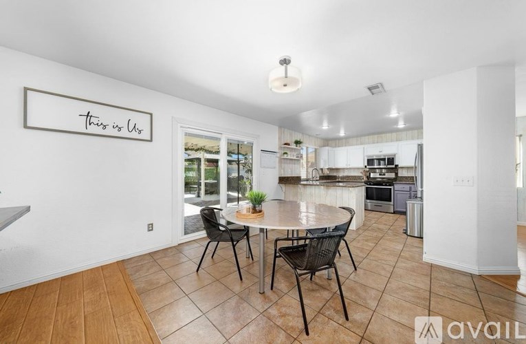 A dining room with a table and chairs and a sign on the wall that says "This is Us".