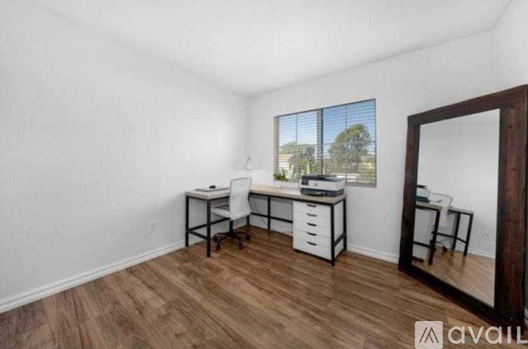 A room with a desk and a chair in it.