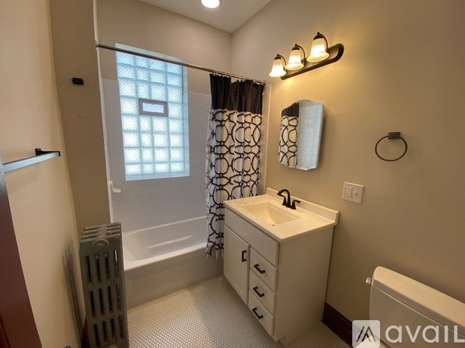 A bathroom with a white sink and a shower with a glass door.