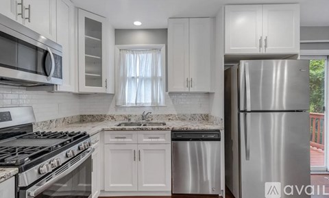 A kitchen with white cabinets and stainless steel appliances.
