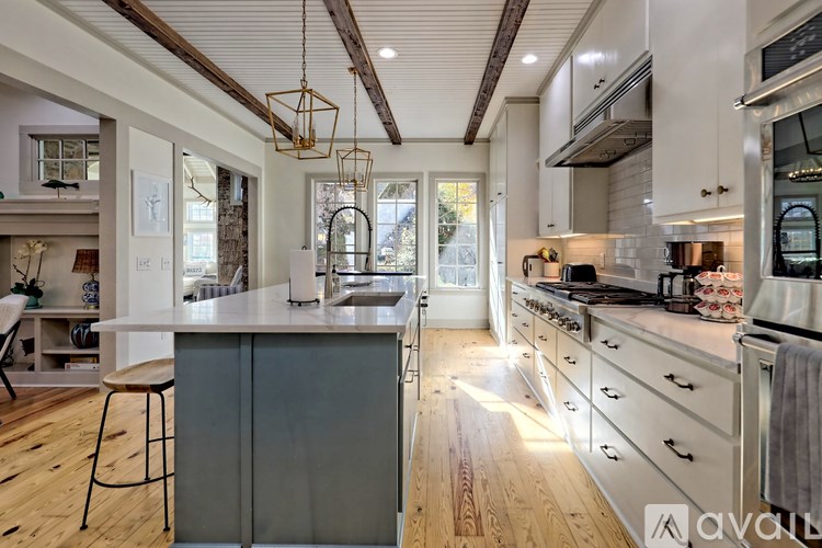 A kitchen with wooden floors and a large island in the middle.