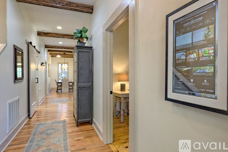 A hallway with a cabinet and a framed picture on the wall.