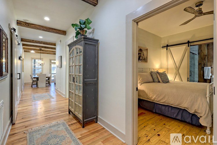 A bedroom with a bed, a dresser, and a ceiling fan.