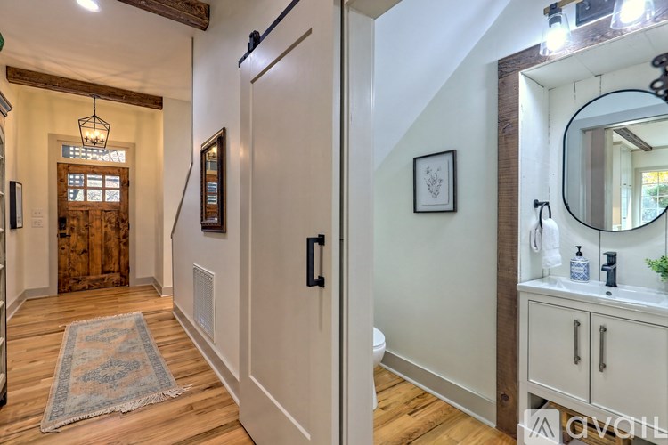 A bathroom with a wooden floor and white walls.