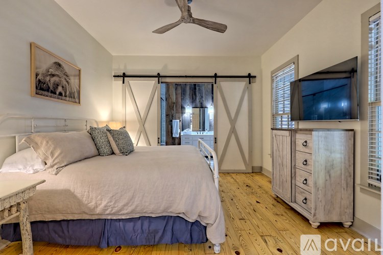 A bedroom with a bed, a dresser, and a ceiling fan.