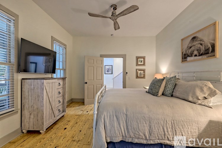 A bedroom with a bed, dresser, and television.