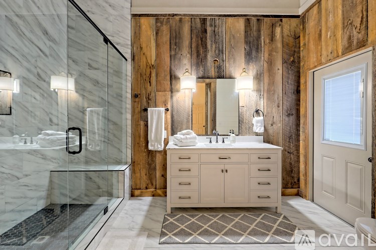 A bathroom with a marble countertop and a wooden wall.