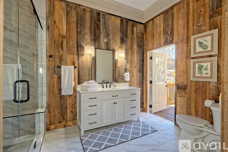 A bathroom with wooden walls and a white vanity.
