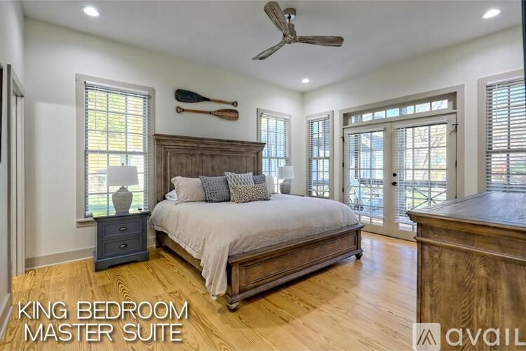 A bedroom with a bed, dresser, and a ceiling fan.