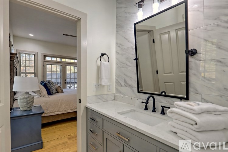 A bathroom with a marble countertop and a large mirror.