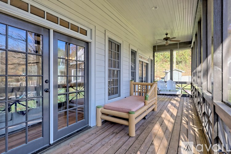 A wooden porch with a bench and a ceiling fan.