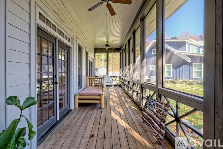 A wooden porch with a bench and a fan.