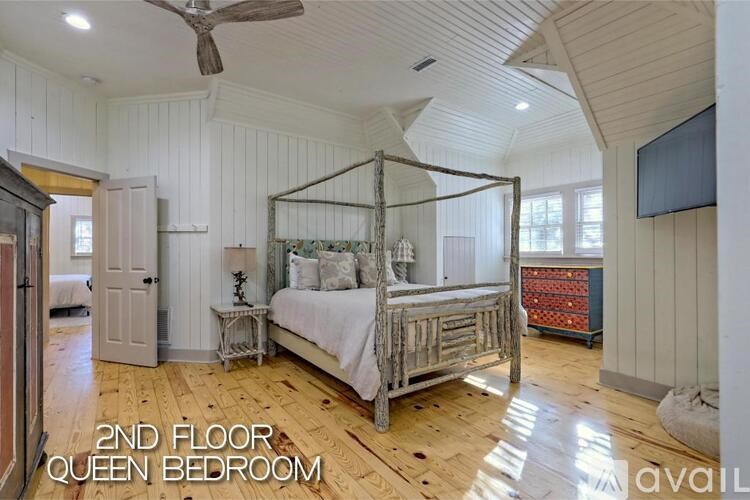 A bedroom with a four poster bed and a ceiling fan.