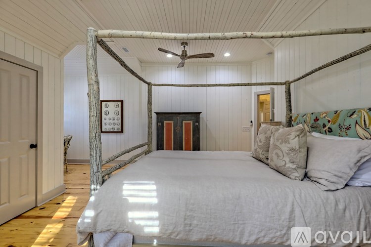 A bedroom with a four poster bed and a ceiling fan.
