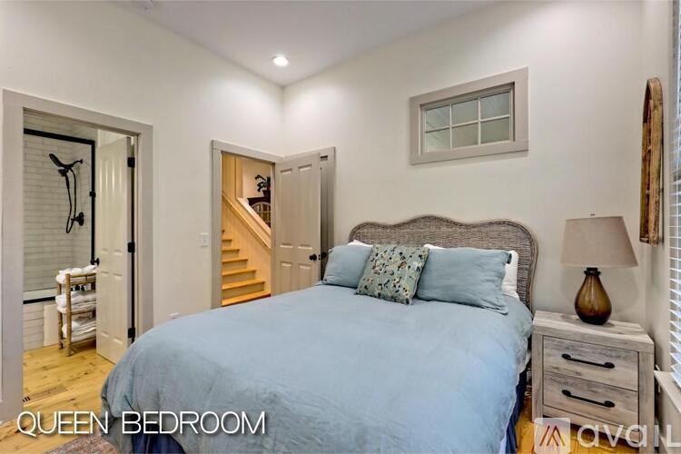 A bedroom with a bed, nightstand, and a window.