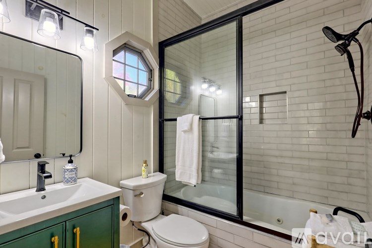 A bathroom with a toilet, sink, and a window.