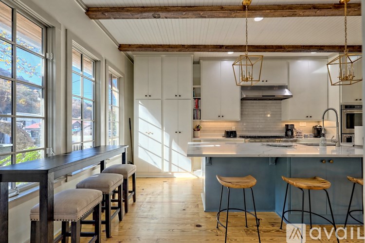 A kitchen with white cabinets and a wooden floor.