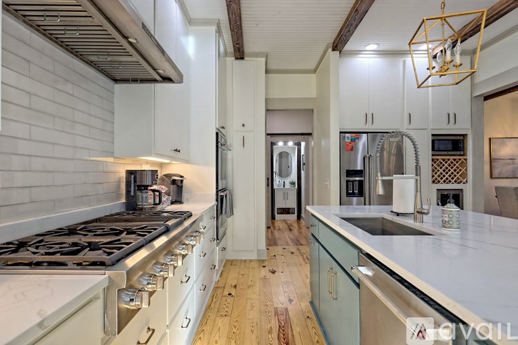 A modern kitchen with a stove top oven and a refrigerator.