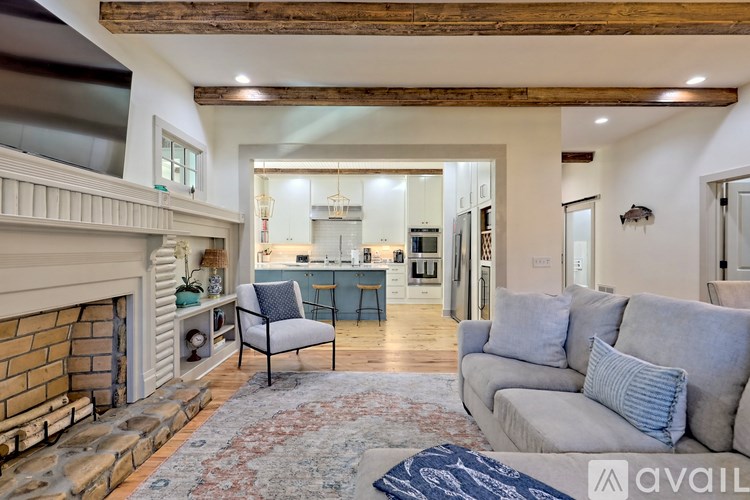 A living room with a fireplace and a grey couch.