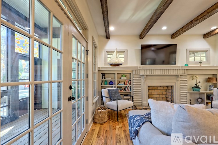 A living room with a fireplace and a television mounted above it.