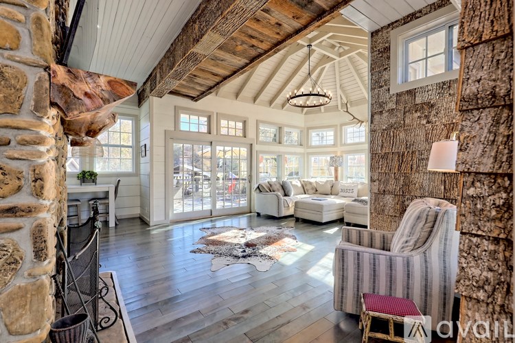 A living room with a stone wall and a striped chair.